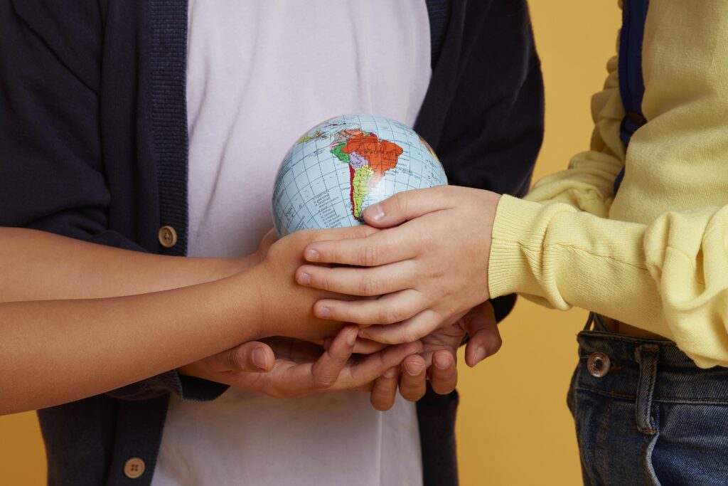 happy school friends holding earth globe